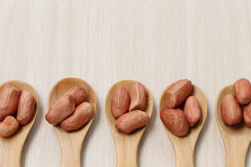 peanut in wooden spoon on wood background.