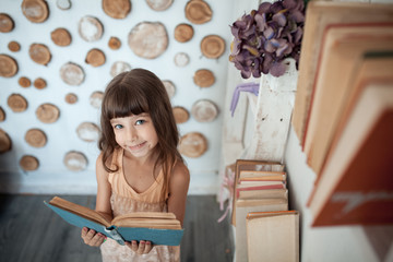 Fototapeta na wymiar little girl smiling and reading book;