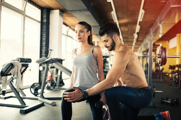 Fototapeta premium Personal trainer giving instructions in gym