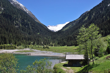 Fototapeta na wymiar Bergsee mit Fischern und schneebedeckten Bergen in den Zillertaler Alpen