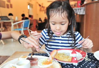 cute little girl eating pasta american breakfast