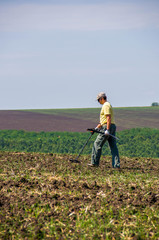 Man with metal detector in a field