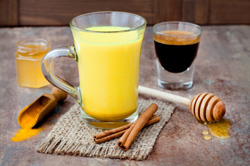 Turmeric golden milk latte with cinnamon sticks and honey. Detox liver fat burner, immune boosting, anti inflammatory healthy cozy drink