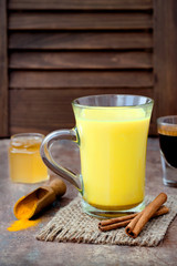 Turmeric golden milk latte with cinnamon sticks and honey. Detox liver fat burner, immune boosting,...