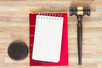Wooden Law Gavel, empty notebook and legal book on wooden table