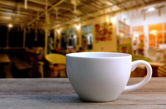 White Coffee Cup On Wooden Table In Coffee Shop Blur Background.