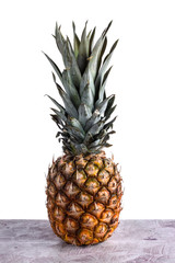 Ripe pineapple on wooden table in photostudio.