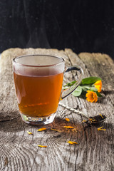 Hot cup of tea with flowers on a wooden table
