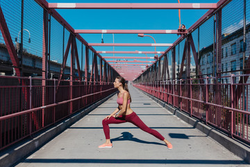 Young Female Runner Doing Stretching . Williamsburg Bridge Brooklyn Nyc