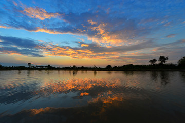 Fototapeta premium Cumulus sunset clouds with sun setting down