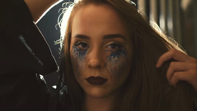 Devilish female enchantress in the black coat posing on the camera 4K