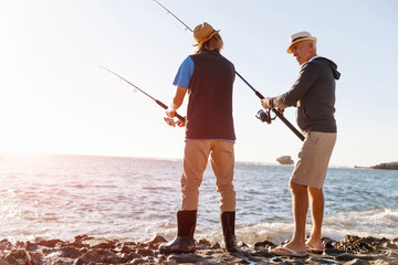 Senior man fishing with his grandson