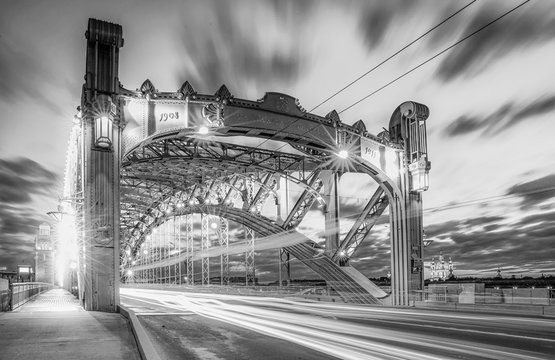 Fototapeta Black and white envelope size view of white night car traffic through the famous Saint Petersburg bridge named after Peter the Great