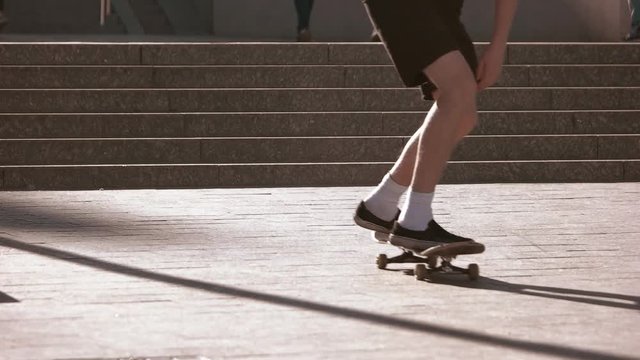 Skateboarder jumping from stairs. Feet on skateboard. Skatepark at daytime. Train your skills.