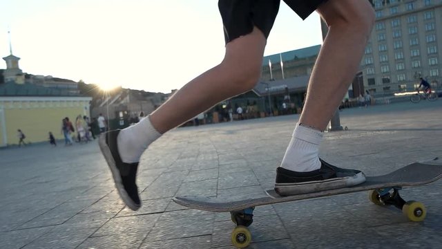 Legs riding a skateboard. Skater in the street. Freedom and boldness. Pick up speed.