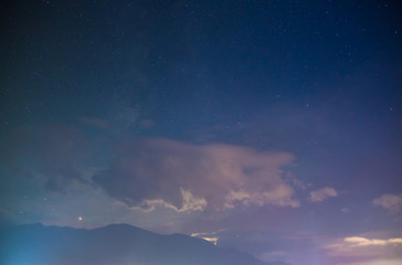 The picturesque mountain view on the background of cloud and starry sky. Wide angle