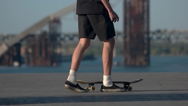Young man holding his skateboard. Skater outdoor at daytime. Sport in the blood. Hobby and lifestyle.