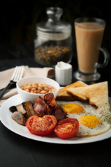 English cooked breakfast with bacon, sausage, fried egg