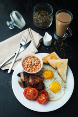 English cooked breakfast with bacon, sausage, fried egg