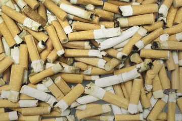A heap of dirty burned cigarette butts. Shot from above.
