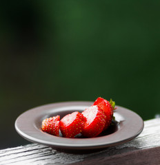 Ripe, juicy, fresh, red strawberries on a saucer