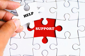 "Help" text on missing puzzle with a hand hold a piece of "Support" text puzzle want to complete it - business and finance concept