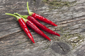 Red hot chili peppers on old wooden table