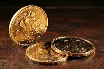 British Sovereign gold coins on rustic wooden background