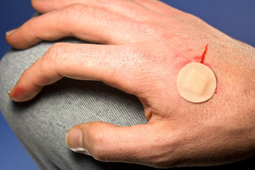 Medicine bandage plaster on a blood wound on a hand