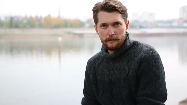 Handsome bearded man on the background of the river