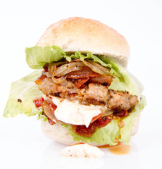 Hamburger with fried onion, tomatoes, iceberg lettuce, mayonnaise and ketchup
