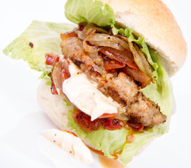 Hamburger with fried onion, tomatoes, iceberg lettuce, mayonnaise and ketchup