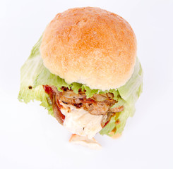 Hamburger with fried onion, tomatoes, iceberg lettuce, mayonnaise and ketchup