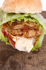 Hamburger with fried onion, tomatoes, iceberg lettuce, mayonnaise and ketchup