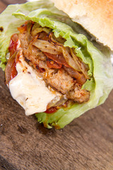 Hamburger with fried onion, tomatoes, iceberg lettuce, mayonnaise and ketchup