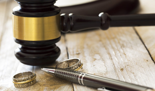 Divorce concept. Close up of wedding rings and judge gavel