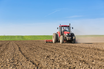 Farmer in tractor preparing land with seedbed cultivator