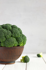 Raw broccoli in a bowl on a wooden table.