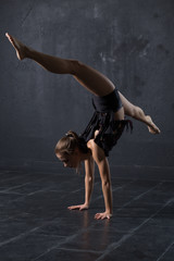 Woman dancer make handstand in dark studio