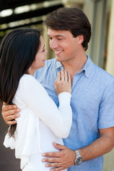 Fototapeta premium Young Couple Cuddling near Stores