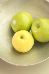 Three green apples on dish
