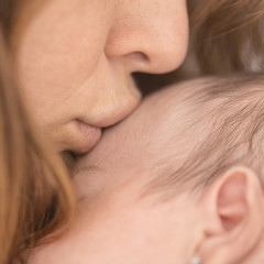 Kissing a white baby face close up