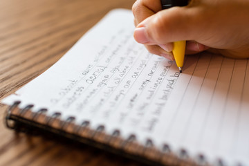 Girl writing by hand on notepad