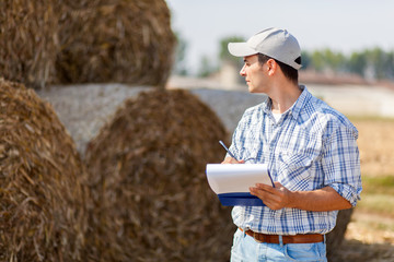 Farmer writing on a clipboard