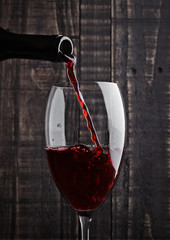 Pouring red wine into the glass from bottle