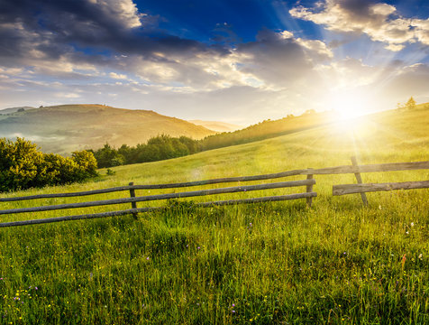 wooden fence on hillside at sunrise