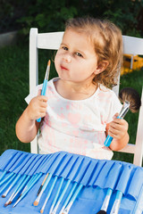 Small girl with beauty brushes