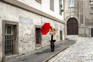 Woman with red umbrella walking in the old town.