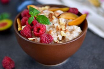 Oatmeal with berries, plums, nuts and honey for breakfast