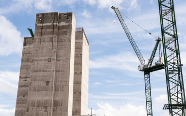 Fototapeta premium Construction site with two big cranes and concrete core of new skyscraper